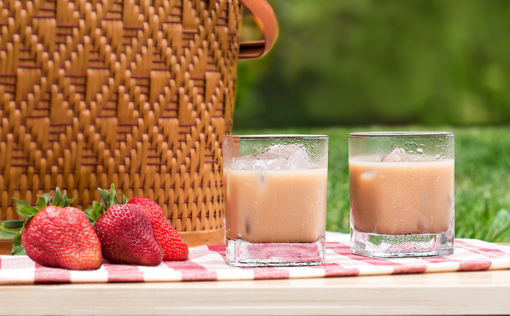 Iced cappuccinos and strawberries on a picnic blanket