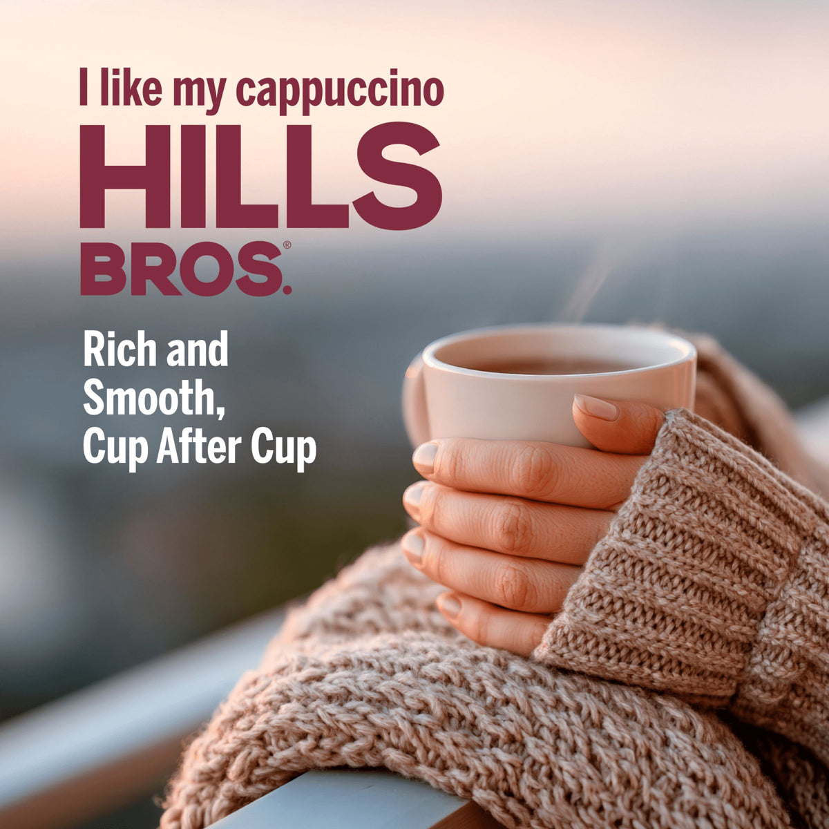 A person in a cozy sweater holds a cup of creamy Hills Bros. Cappuccino French Vanilla—Instant Cappuccino Mix, 52 oz resealable pouch—celebrating its rich and smooth flavor, sip after delicious sip.