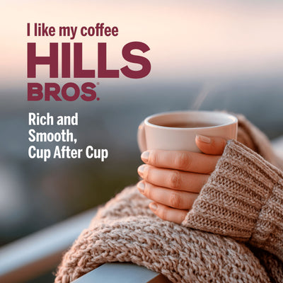 A person in a cozy sweater holds a cup of coffee on a balcony. Text on image promotes Hills Bros. Coffee Original Blend, Medium Roast, as "Rich and Smooth, Cup After Cup," made from premium ground beans for exceptional flavor.