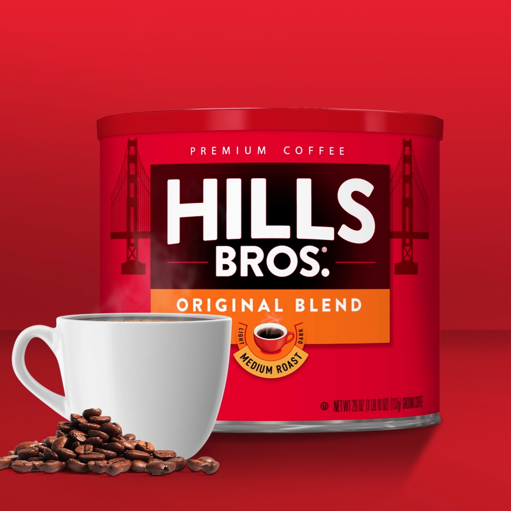 A red container of Hills Bros. Original Blend coffee is displayed with a steaming white cup of coffee and coffee beans, set against a red background.