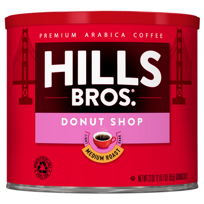 A red can of Hills Bros. Coffee Donut Shop Medium Roast Ground, made from premium Arabica beans, featuring Golden Gate Bridge artwork in the background.