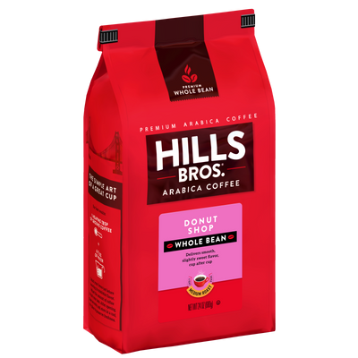 A red bag of Hills Bros. Coffee Donut Shop Medium Roast Whole Bean, 12 oz., featuring premium Arabica beans and distinctive branding and product details on the front.