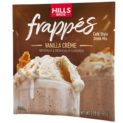 A packet of Hills Bros. Frappés Vanilla Creme drink mix, featuring a creamy frozen beverage topped with whipped cream and wafer pieces.