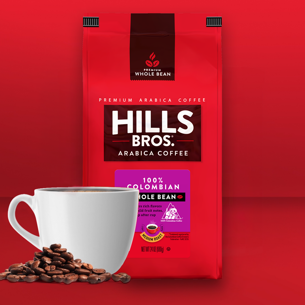 A package of Hills Bros. premium Arabic coffee beans with a white cup of coffee and scattered coffee beans on a red background.
