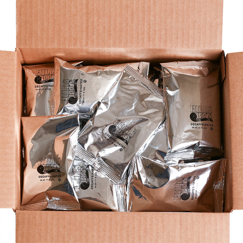 A box of silver foil packets containing Hills Bros. Coffee Decaf Original Blend - Medium Roast - Ground in a cardboard box.